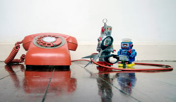 two robots cutting the line of an old red phone representing a t1 landline and PRI